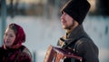 Russian folklore - russian man playing accordion outdoors and woman standing next by him