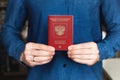 Russian foreign passport in the hands of a man in a blue denim shirt