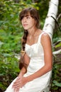 Russian girl in white dress in a birch forest Royalty Free Stock Photo