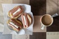 russian hot sandwiches with cheese, sausages and mayonnaise with cup of coffee with milk on table with square pattern Royalty Free Stock Photo