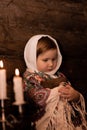 Russian hut tsarist Russia, a little girl in Russian national clothes is leaning on a log wall and embracing an ancient Royalty Free Stock Photo