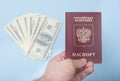 Russian international passport in the man`s hand. Dollars. Blue