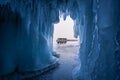Russian local van on Baikal frozen lake in front of ice cave, Baikal in winter, Siberia, Russia