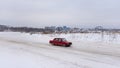 Russian low red car `VAZ Zhiguli` quickly goes in a skid on the winter road, turning the steering wheel