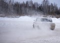 Russian modified old car `VAZ-Zhiguli` goes fast drift turning the wheels raising snow.