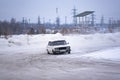 Russian modified white car `VAZ-Zhiguli` goes fast drift turning the wheels raising snow