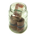 Russian money banknotes of five thousand rubles are rolled up and lie in a glass jar. Several packs of large rubles