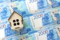 Russian money with a face value of two thousand rubles and a wooden house, the concept of buying a home Royalty Free Stock Photo