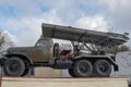 Russian multiple rocket launcher artillery mounted on soviet military truck, missile artillery combat vehicle on a beige pedestal