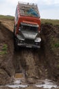 Russian off-road extreme expedition truck Ural driving on dirty muddy mountain road, transportation tourists