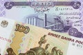 A Russian one hundred ruble note paired with a purple fifty dinar bill from Iraq.