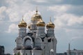 Russian Orthodox Church with golden domes against the background of clouds and blue sky Royalty Free Stock Photo