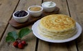 Russian pancakes crepes with raspberry jam, applesauce and sour cream on rustic wooden background. Stack of russian pancake blini Royalty Free Stock Photo