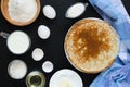 Russian pancakes with ingredients for cooking on black background Royalty Free Stock Photo