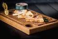 Pancakes with sugar powder and jam on a wooden board. Dark table, empty space. Maslenitsa, russian carnival