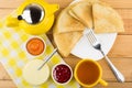 Russian pancakes in plate, jam, condensed milk, teapot and tea