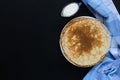 Russian pancakes and sour cream with checker napkin on black background. Royalty Free Stock Photo