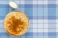 Russian pancakes with sour cream on checker tablecloth Royalty Free Stock Photo