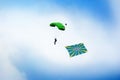 Russian paratrooper jumps with a parachute with Flag of Russian Air Force on clear blue sky and white clouds background