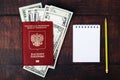 A Russian passport with American dollars and a note with a pencil