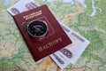 Russian passport with a compass and Russian money on a geographical map