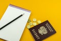 Russian passport and several coins. Notepad for entries on an orange background Royalty Free Stock Photo