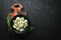 Russian pelmeni meat Dumplings with greens in a black plate. Russian traditional cuisine. Top view. Royalty Free Stock Photo