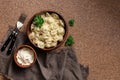 Russian pelmeni meat Dumplings with sour cream on a brown background. Overhead view, copy space Royalty Free Stock Photo