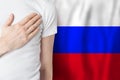 Russian person with hand on heart on the background of Russia flag. Patriotism, country, national, pride concept Royalty Free Stock Photo