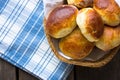 Russian pirozhki, baked patties or pies on basket with jug of milk. top view