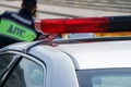 A Russian police officer is standing next to a patrol car with a red siren. The inscription on the uniform: traffic police