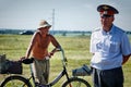 A Russian policeman stands near a naked man with a bicycle