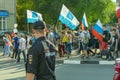 Russian policeman in uniform with a badge on the street at a rally of protest, view from the back