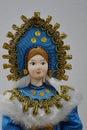 Russian porcelain woman doll in tranditional blue winter costume with golden jewellry decorated headdress called kokoshnik