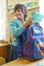 Russian pupil girl junior classes collects schoolbag in rural s