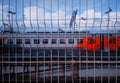 Russian railway train through jail fence background