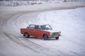 Russian red old car `VAZ Zhiguli` goes fast sideways in winter turning the wheel on the turn of the snow Royalty Free Stock Photo