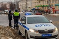 Russian road police officers standing near patrol car on winter road - close-up with selective focus on roof lamp. Royalty Free Stock Photo