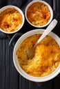 Russian Romanoff casserole made from potatoes, sour cream and cheddar cheese close-up in a pan. Vertical top view