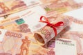 Russian roubles with red bow isolated on the money background. Royalty Free Stock Photo