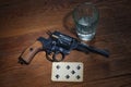 Russian roulette - Seven of Spades plaing card, glass of vodka and revolver with one cartridge in drum Royalty Free Stock Photo