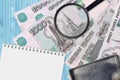 1000 russian rubles bills and magnifying glass with black purse and notepad. Concept of counterfeit money. Search for differences Royalty Free Stock Photo