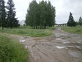 Traditional Russian countryside landscape with dirty Russian roads. Puddles, dirt, bumps and bumps.