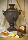 Russian samovar, tea with lemon in faceted glasses with cup holders and bublik. Tinted photo in vintage style Royalty Free Stock Photo