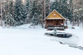 Russian sauna banja house in winter forest nearby the lake with ice-hole