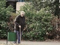 Russian seniors - poorly dressed old man with a walking canÃÆ looking into street garbage can