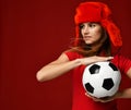 Russian style fan sport woman player in red uniform and ear-flap hat hold soccer ball celebrating happy smiling Royalty Free Stock Photo