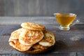 Russian-style fritters and honey on dark wooden background. Empty space