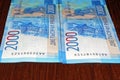 Russian two thousandth notes close-up against the background of a dark wooden table Royalty Free Stock Photo