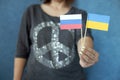 Russian and Ukraine flags and peace symbol on female shirt. Stop war concept. Russia Ukraine conflict